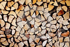 Stack of round and square natural firewood in preparation for the winter