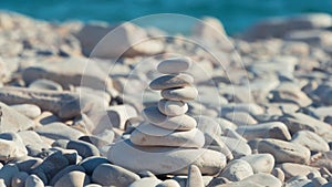 A stack of round stones standing on the shore of a sea. Concept of balance and harmony. Rocks on the coast of the Sea in