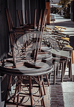 Stack of Round table and Dark green Khaki color, Yellow plastic chairs are beside of The cafe terrace