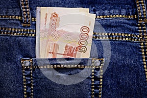 A stack of Russian five-thousandth ruble bills in a pocket of blue jeans. Money in your pocket, cash.