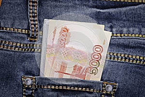 A stack of Russian five-thousandth ruble bills in a pocket of blue jeans. Money in your pocket, cash.