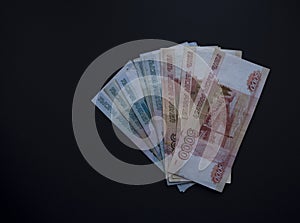 Stack of Russian money banknotes of five thousand and one thousand rubles on black background