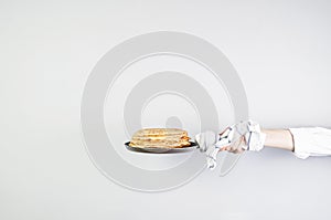 Stack of russian pancake blini in pan woman holds in hands