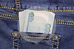 A stack of Russian thousand-ruble bills in a pocket of blue jeans. Money in your pocket, cash.