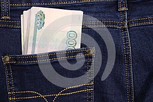 A stack of Russian thousand-ruble bills in a pocket of blue jeans. Money in your pocket, cash. Travel concept