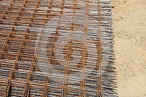 Stack of rusty wire mesh at a construction site. Metal building grate.
