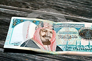 Stack of 20 Saudi riyals cash banknotes on a wooden table photo