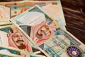 Stack of 20 Saudi riyals cash banknotes on a wooden table photo
