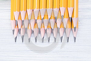 stack of sharpened simple pencils, lie on a light background