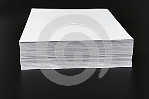 a stack of sheets of white paper on a black background.
