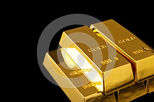 Stack of shiny gold bars on black background.