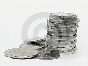 Stack of silver coins on a white surface representing savings and wealth