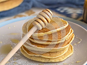Stack of Small pancakes in syrup. Tasty mornings pancakes poured with honey