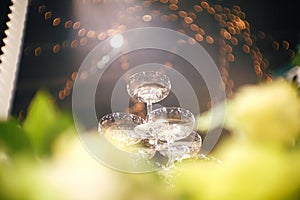 Stack small tower of champagne glass for the bride and groom for pouring champagne at the Wedding Ceremony with bokeh light