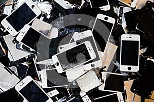 Stack of smart phones with cracked and damaged LCD screen