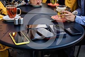 Stack of smartphones on black table at the cafe