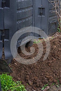 A stack of soil in front of the composter