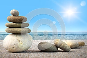 Stack of spa rocks on wood against blue sky