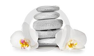 Stack of spa stones and beautiful flowers on white background