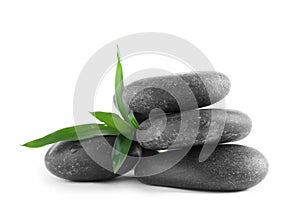 Stack of spa stones and leaves with water  on white background