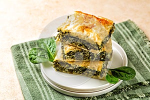 Stack of Spanakopita piece of pie, homemade Greek savory spinach pastry.