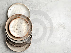 Stack of speckled ceramic plates with a neutral tone