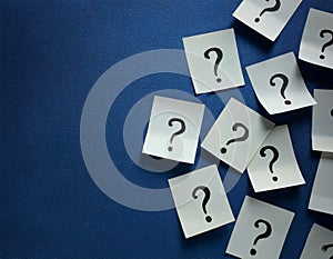 Paper notes with question marks on Navy background, flat lay. Space for text