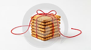 Stack of Square Cookies Tied with Red String on White Background