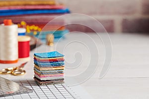 Stack of square pieces of colorful fabrics, accessories for quilting