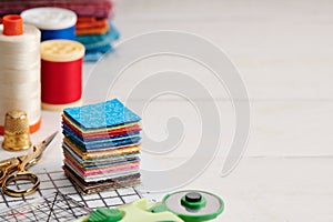 Stack of square pieces of colorful fabrics, accessories for quilting