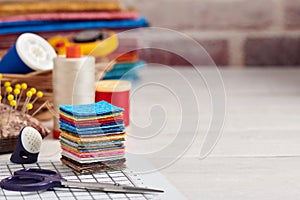 Stack of square pieces of colorful fabrics, accessories for quilting