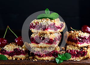 Stack of square slices of a pie with a cherry