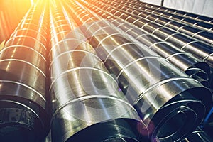 Stack of steel or metal pipes or round tubes as industrial background with perspective and sunshine effect