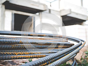 Stack of steel rebar for reinforcement concrete with house under construction