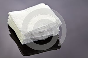 Stack of sterile gauze pad on dark background.