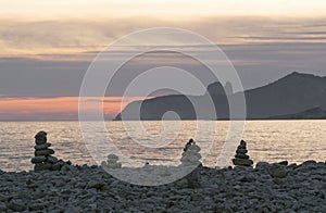 Stack of stones on beach, sea and sky at sunset