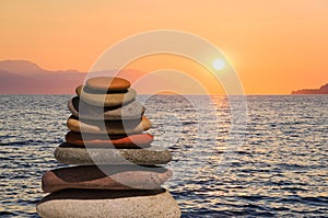 Stack of stones on beach at sunset