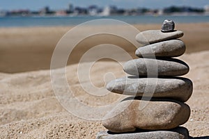 Stack of stones on beautiful sandy beach near sea, closeup. Space for text