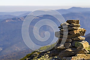 Stack of stones covered with moss on top of a mountain on mountains background. Concept of balance and harmony. Stack of zen rocks