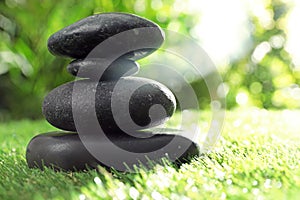 Stack of stones on green grass against blurred background. Zen concept