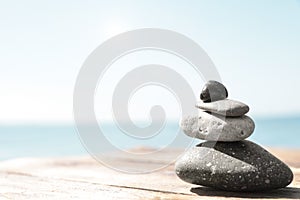 Stack of stones on  pier near sea, space for text. Zen concept