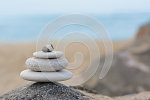 Stack of stones on rock near sea, space for text