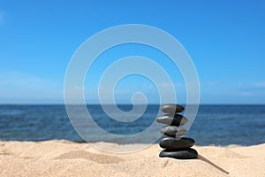 Stack of stones on sand near sea. Zen concept