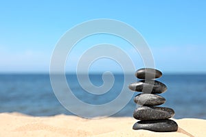 Stack of stones on sand near sea. Zen concept