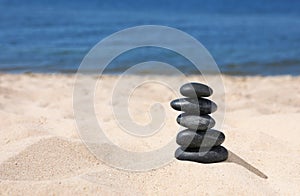 Stack of stones on sand near sea. Zen concept