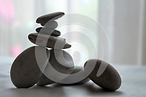 Stack of stones. Stack of stone. White stones balance on white light indoor background.