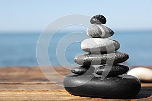 Stack of stones on wooden pier near sea seascape. Zen concept