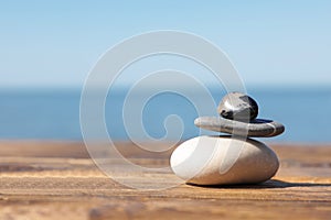 Stack of stones on wooden pier near sea. Zen concept