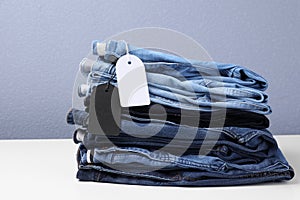 Stack of stylish jeans with tags