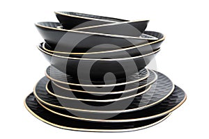 Set of ceramic tableware isolated on white background. Plates of different shapes standing on top of each other. Stack
